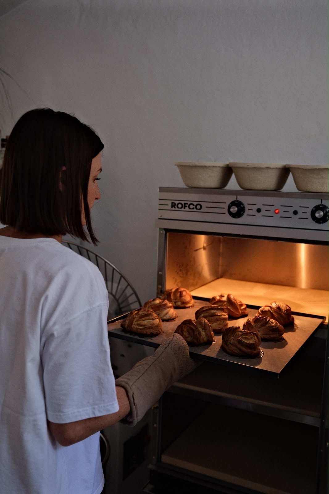 Die Bäckerin holt Zimtknoten aus dem Ofen
